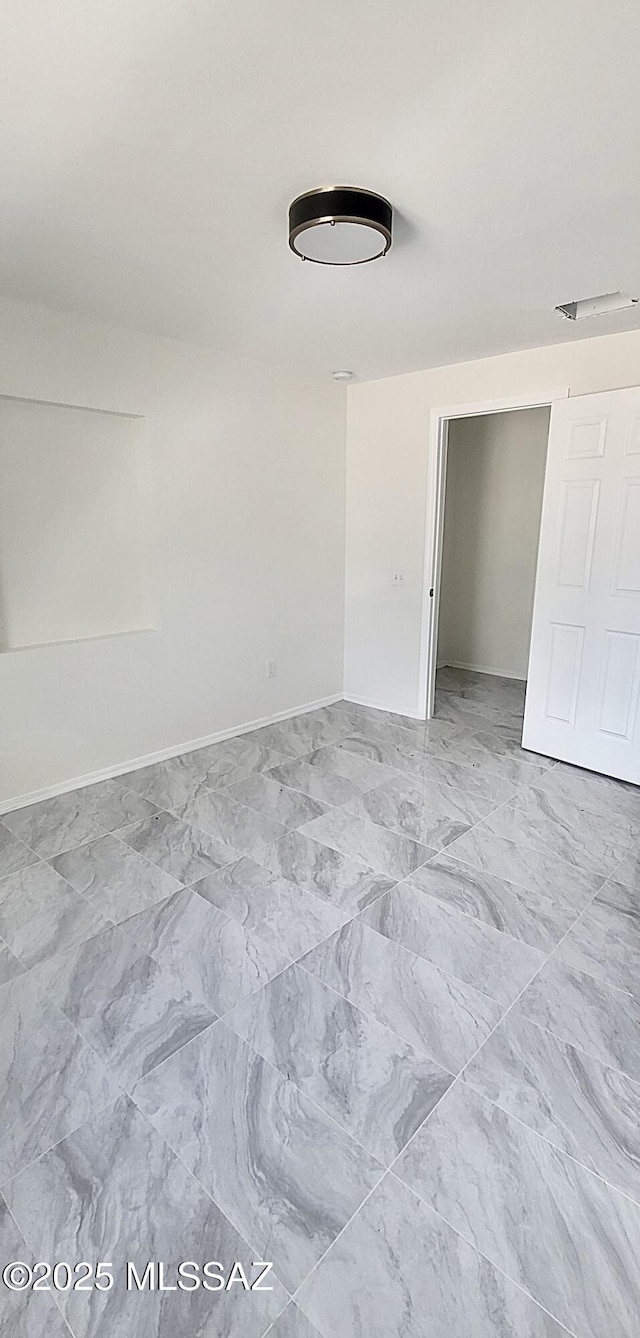 empty room with baseboards and marble finish floor