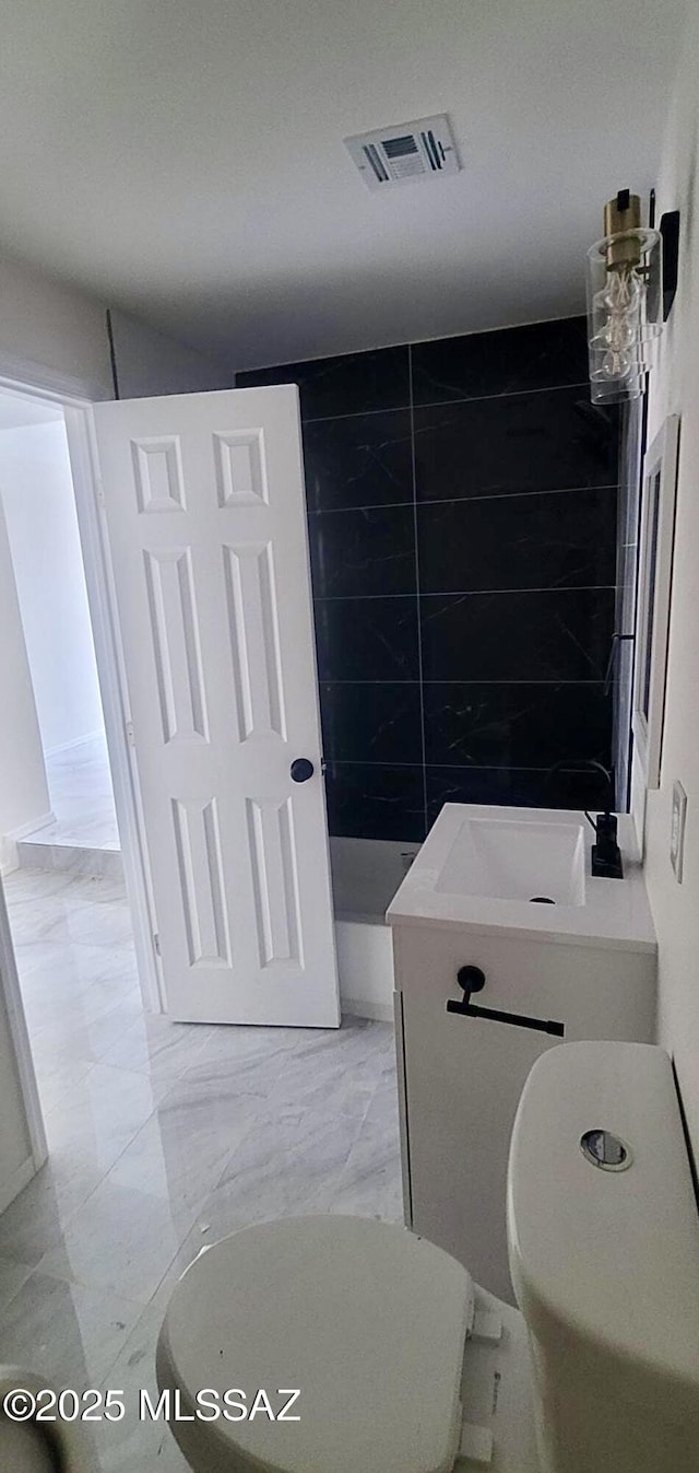 bathroom featuring toilet, visible vents, and marble finish floor