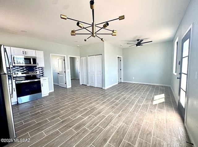 kitchen with baseboards, stainless steel appliances, wood finished floors, and white cabinetry