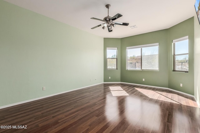 spare room featuring ceiling fan and dark hardwood / wood-style floors