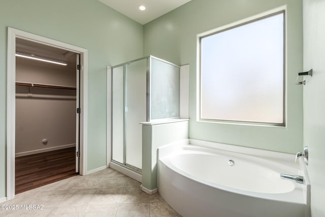 bathroom featuring tile patterned flooring and shower with separate bathtub