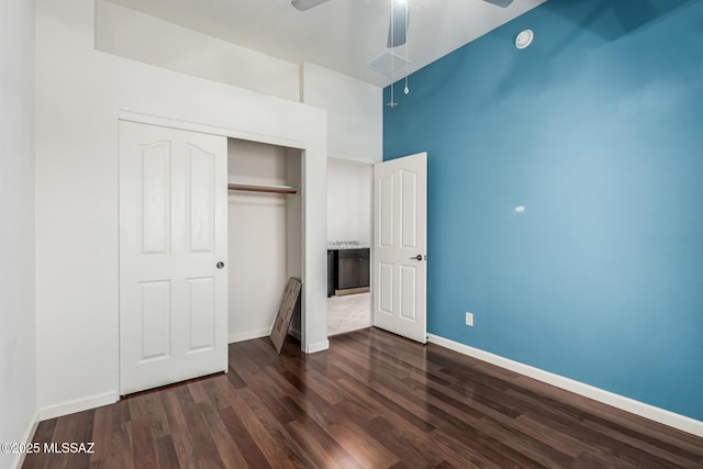 unfurnished bedroom featuring dark hardwood / wood-style flooring, a closet, and ceiling fan