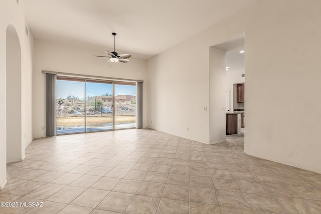 tiled spare room with ceiling fan