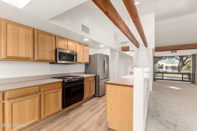 kitchen with appliances with stainless steel finishes, sink, light wood-type flooring, light brown cabinets, and beam ceiling