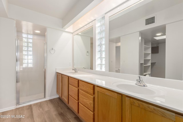 bathroom featuring a shower with door, vanity, and wood-type flooring