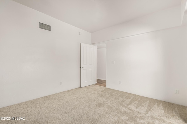 unfurnished room featuring light colored carpet