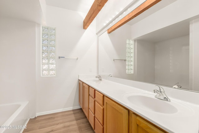 bathroom with vanity, hardwood / wood-style floors, and a washtub