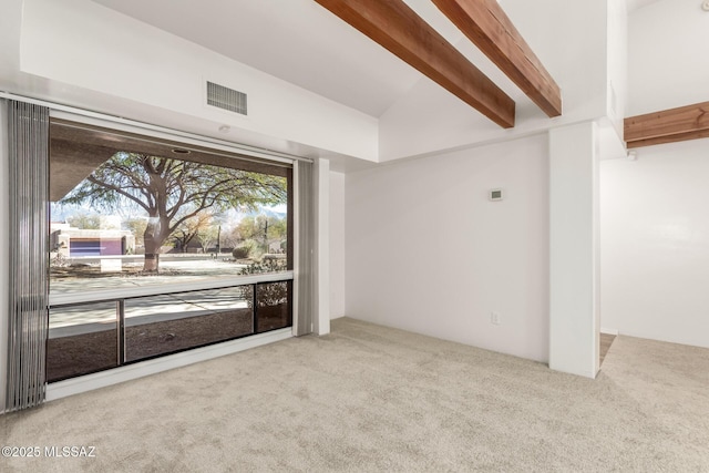 carpeted spare room with beamed ceiling