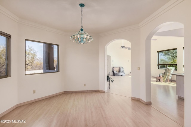 unfurnished room featuring wood-type flooring, ornamental molding, and an inviting chandelier