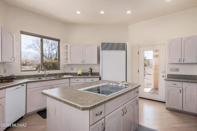 kitchen featuring white dishwasher, sink, and white cabinetry