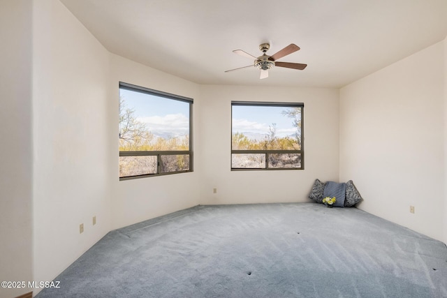 carpeted spare room with ceiling fan