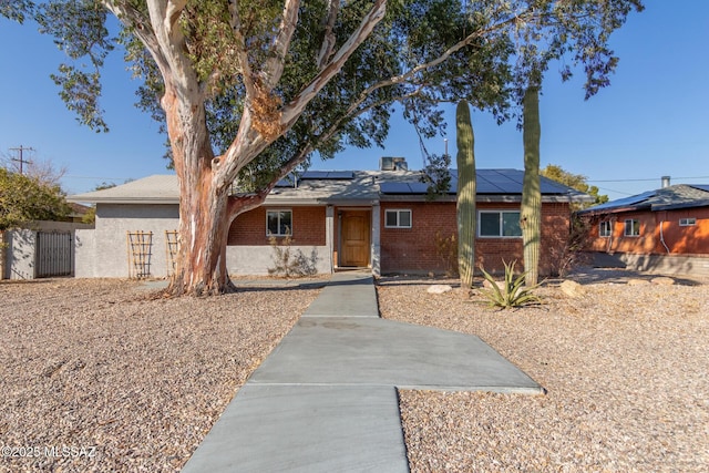 ranch-style house featuring solar panels