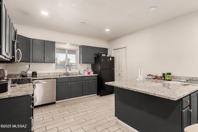 kitchen featuring sink, gray cabinetry, kitchen peninsula, stainless steel appliances, and light stone countertops