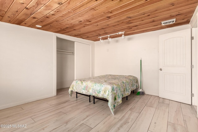 bedroom with track lighting, wood ceiling, and light hardwood / wood-style floors