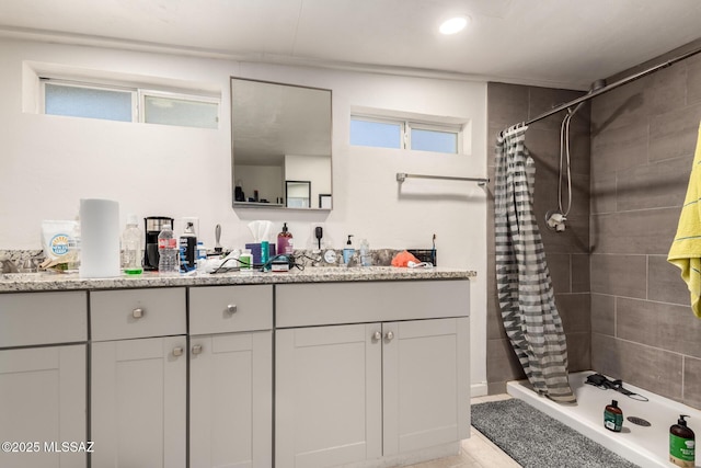 bathroom with walk in shower and vanity