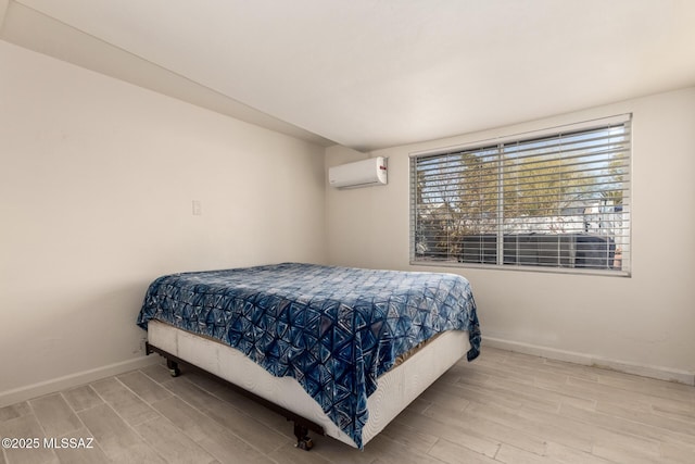 bedroom with hardwood / wood-style flooring and a wall unit AC