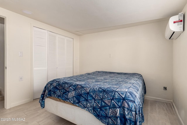 bedroom featuring hardwood / wood-style floors, a wall mounted AC, and a closet