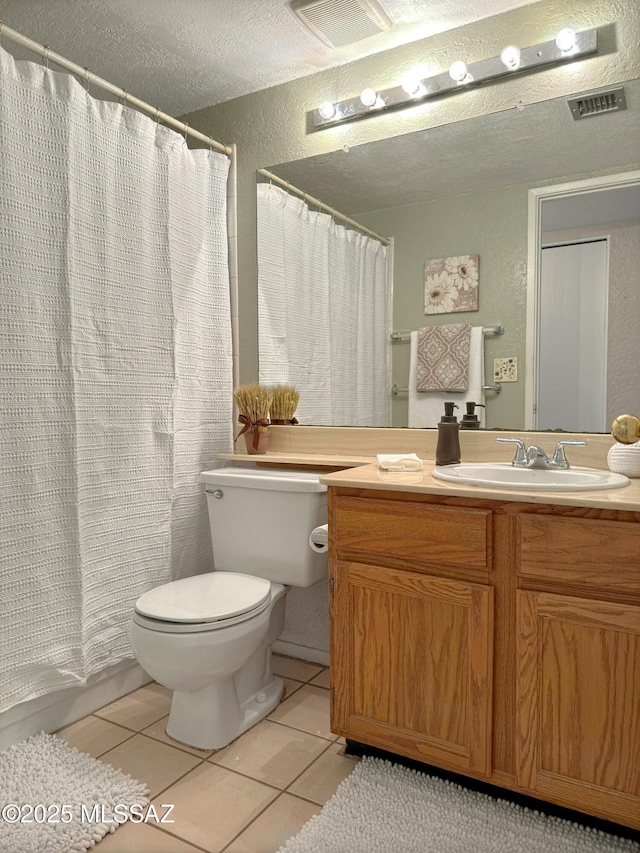 bathroom featuring vanity, tile patterned floors, toilet, and a textured ceiling