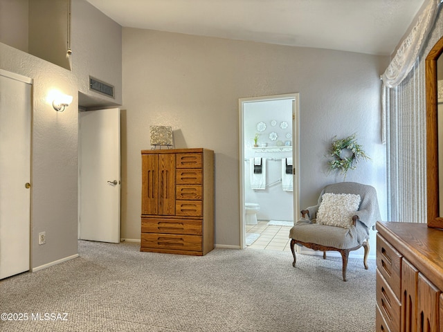 sitting room with vaulted ceiling and light colored carpet