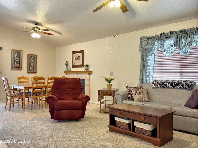 living room with tile patterned flooring, ceiling fan, lofted ceiling, and a textured ceiling