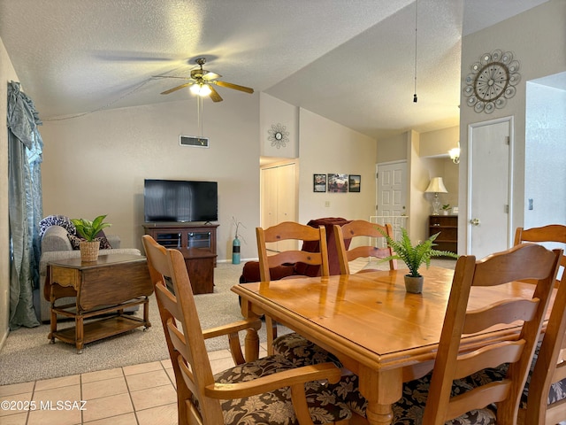 dining space featuring vaulted ceiling, light tile patterned floors, a textured ceiling, and ceiling fan