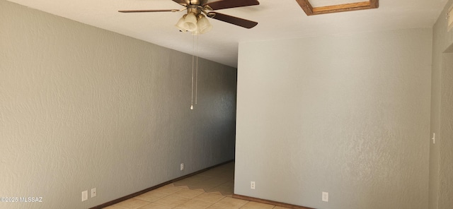 tiled spare room with ceiling fan