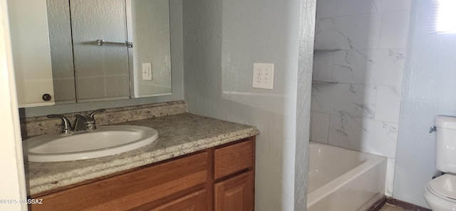 full bathroom with tiled shower / bath combo, vanity, and toilet