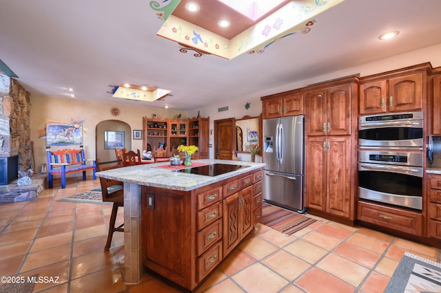 925 N Rancho Del Jefe Loop, Tucson, AZ 85748 - kitchen with appliances with stainless steel finishes, light tile patterned floors, a center island, recessed lighting, and arched walkways