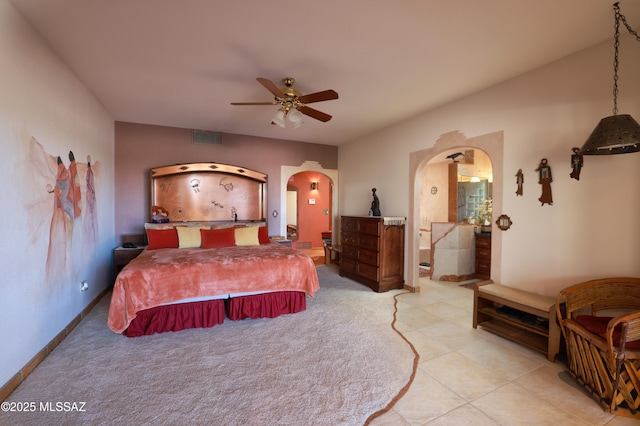 925 N Rancho Del Jefe Loop, Tucson, AZ 85748 - bedroom with arched walkways, a ceiling fan, light carpet, and ensuite bathroom