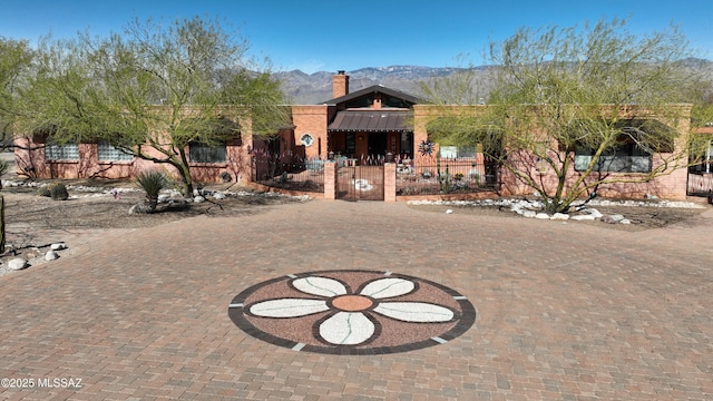 925 N Rancho Del Jefe Loop, Tucson, AZ 85748 - view of front of home with a fenced front yard, a chimney, a mountain view, and a gate
