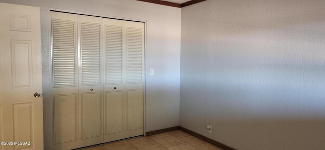 unfurnished bedroom with light tile patterned floors and a closet