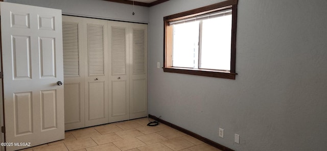 unfurnished bedroom with light tile patterned flooring and a closet