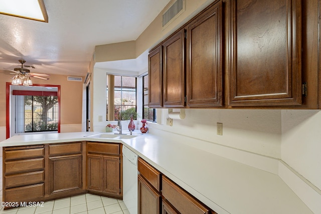 kitchen with sink, light tile patterned floors, kitchen peninsula, dishwasher, and ceiling fan