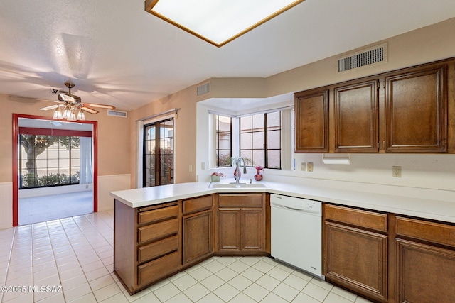 kitchen featuring sink, light tile patterned floors, kitchen peninsula, and dishwasher