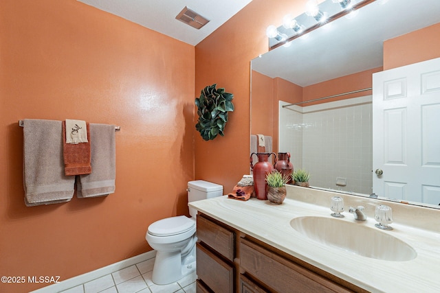 bathroom with tiled shower, vanity, toilet, and tile patterned flooring