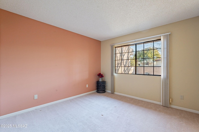 carpeted empty room featuring a textured ceiling