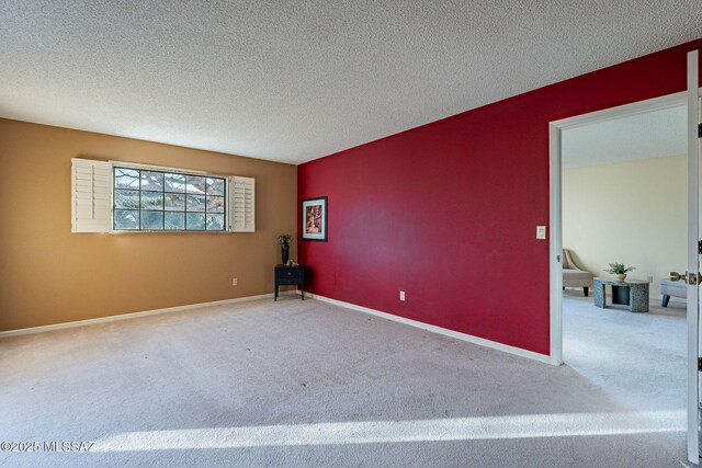 carpeted empty room featuring a textured ceiling