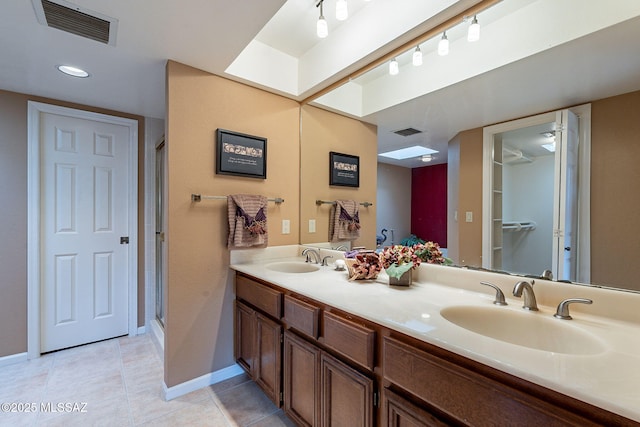 bathroom featuring vanity, a shower with door, and tile patterned floors