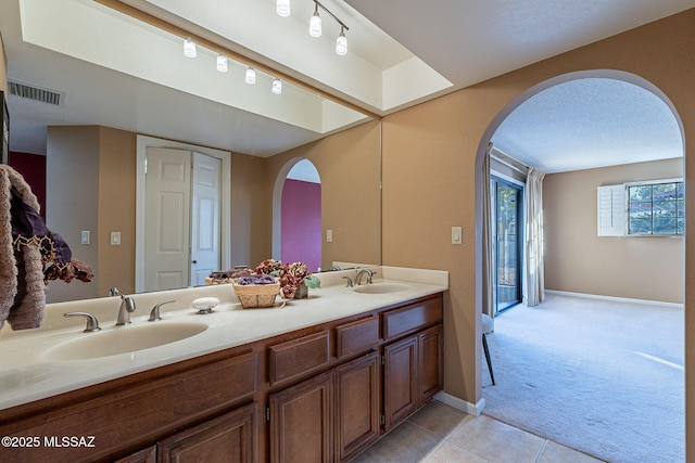 bathroom with vanity, tile patterned flooring, and a textured ceiling