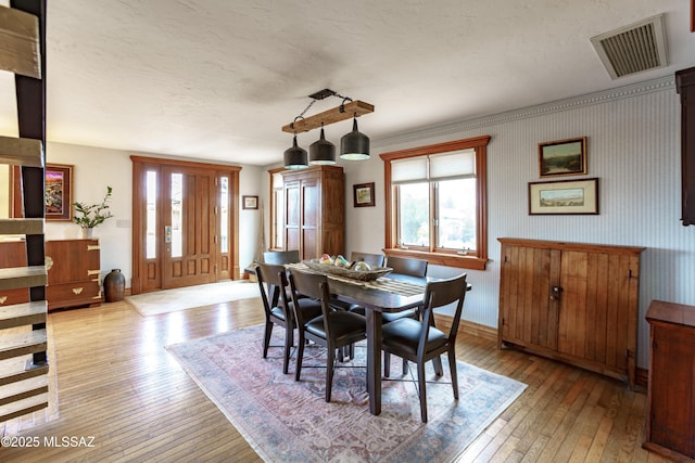 dining room with light hardwood / wood-style flooring and a textured ceiling