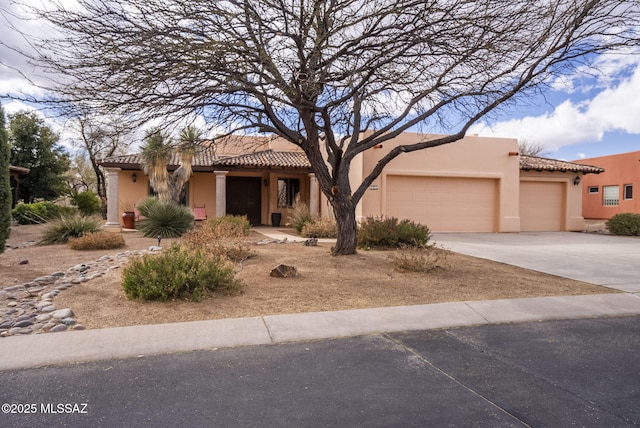 view of front facade featuring a tiled roof, an attached garage, driveway, and stucco siding