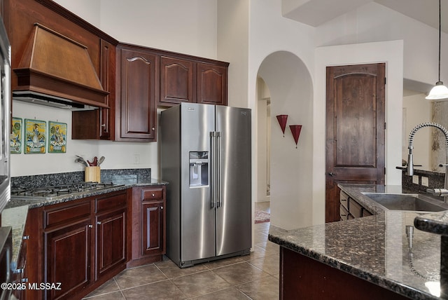 kitchen with custom exhaust hood, dark tile patterned flooring, a sink, and stainless steel appliances