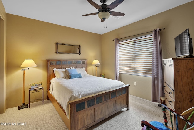 bedroom with light carpet and a ceiling fan