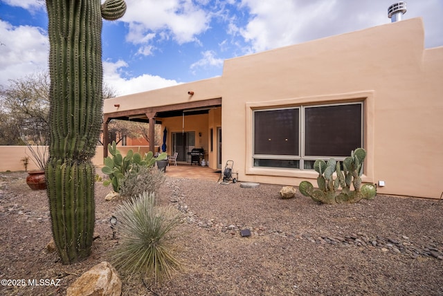 back of property with a patio, stucco siding, and fence
