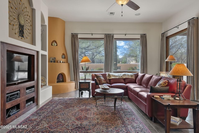 living room featuring visible vents, a ceiling fan, tile patterned flooring, and a healthy amount of sunlight