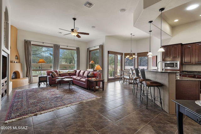 living room with visible vents, recessed lighting, plenty of natural light, and ceiling fan with notable chandelier