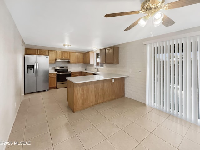 kitchen featuring appliances with stainless steel finishes, radiator heating unit, sink, light tile patterned floors, and kitchen peninsula