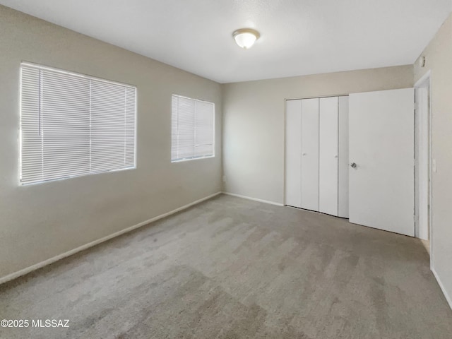 unfurnished bedroom featuring light carpet and a closet