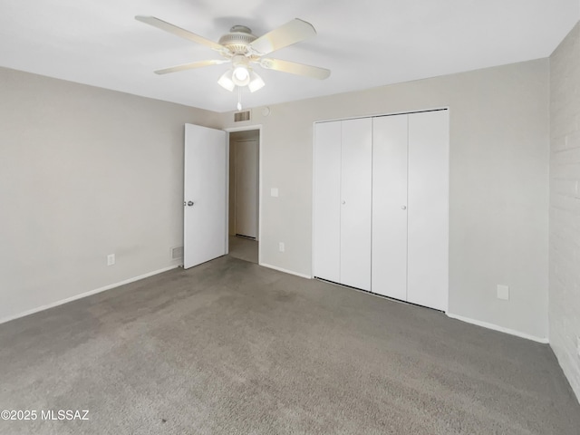 unfurnished bedroom featuring dark carpet, a closet, and ceiling fan