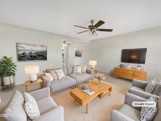 tiled living room with ceiling fan and brick wall